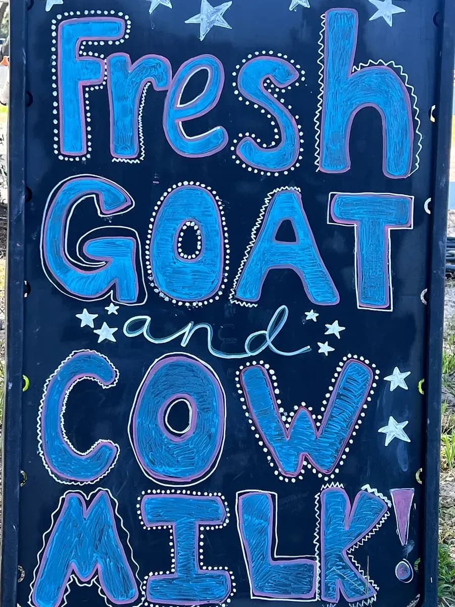 Hand-painted chalkboard sign: Fresh Goat and Cow Milk