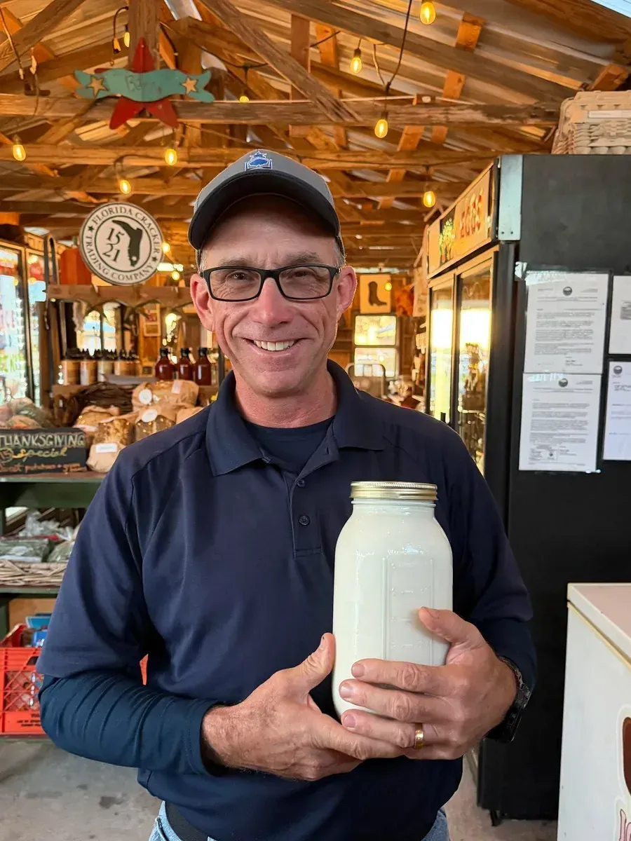 Longtime customer Mr. Tim holding a jar of Heartland milk at the market