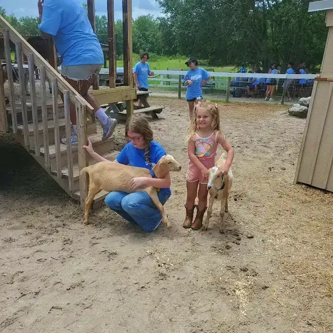 Children interacting with goats during a field trip at the ranch