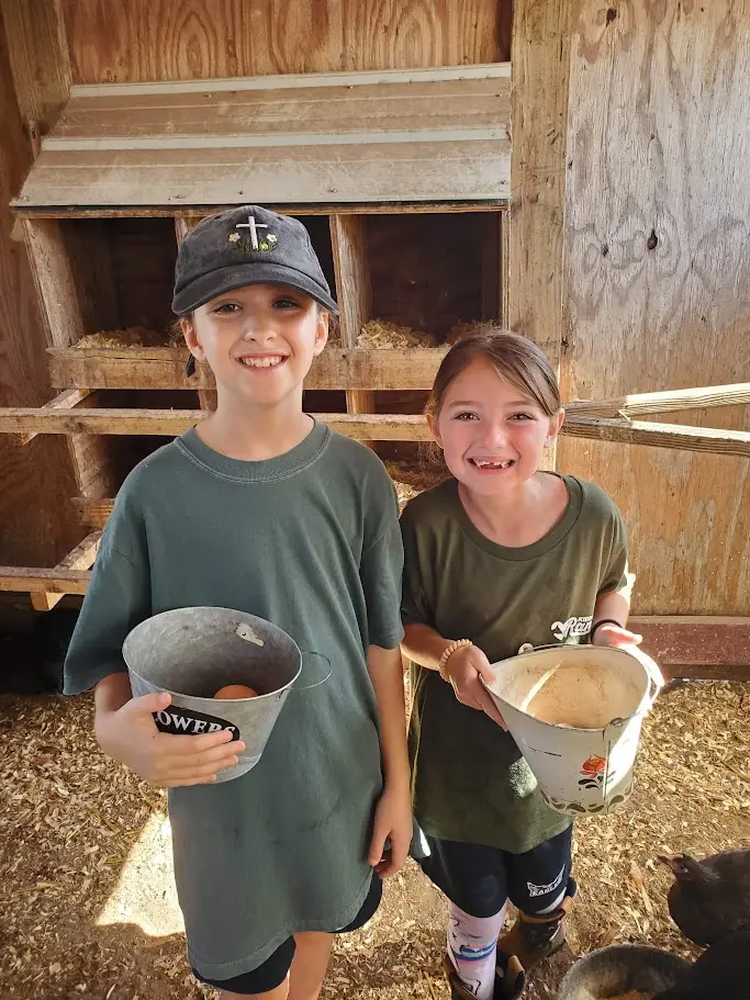 Sprouts students with egg collection buckets in the barn